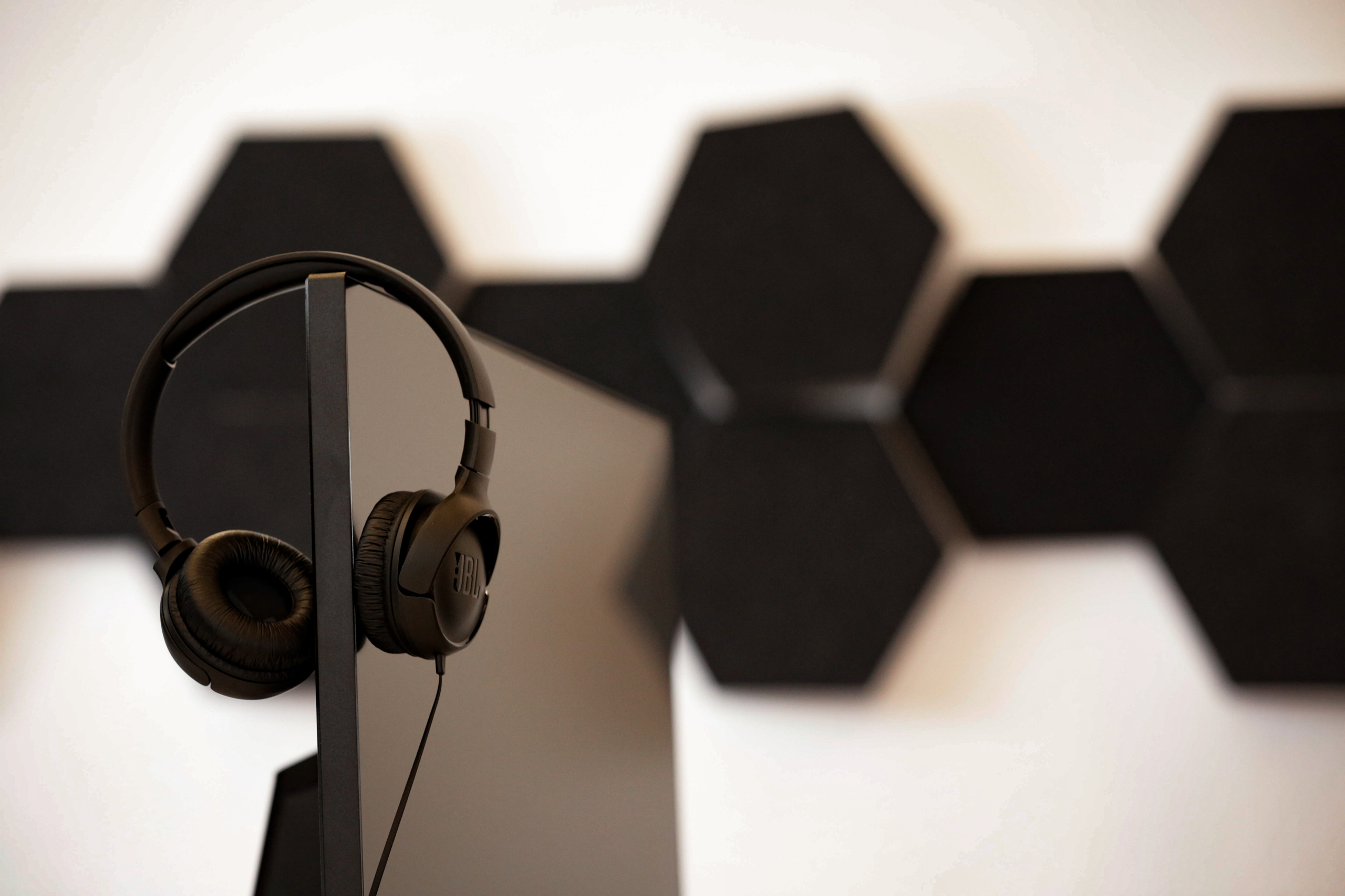 Kopfhörer hängen über einem Bildschirm.