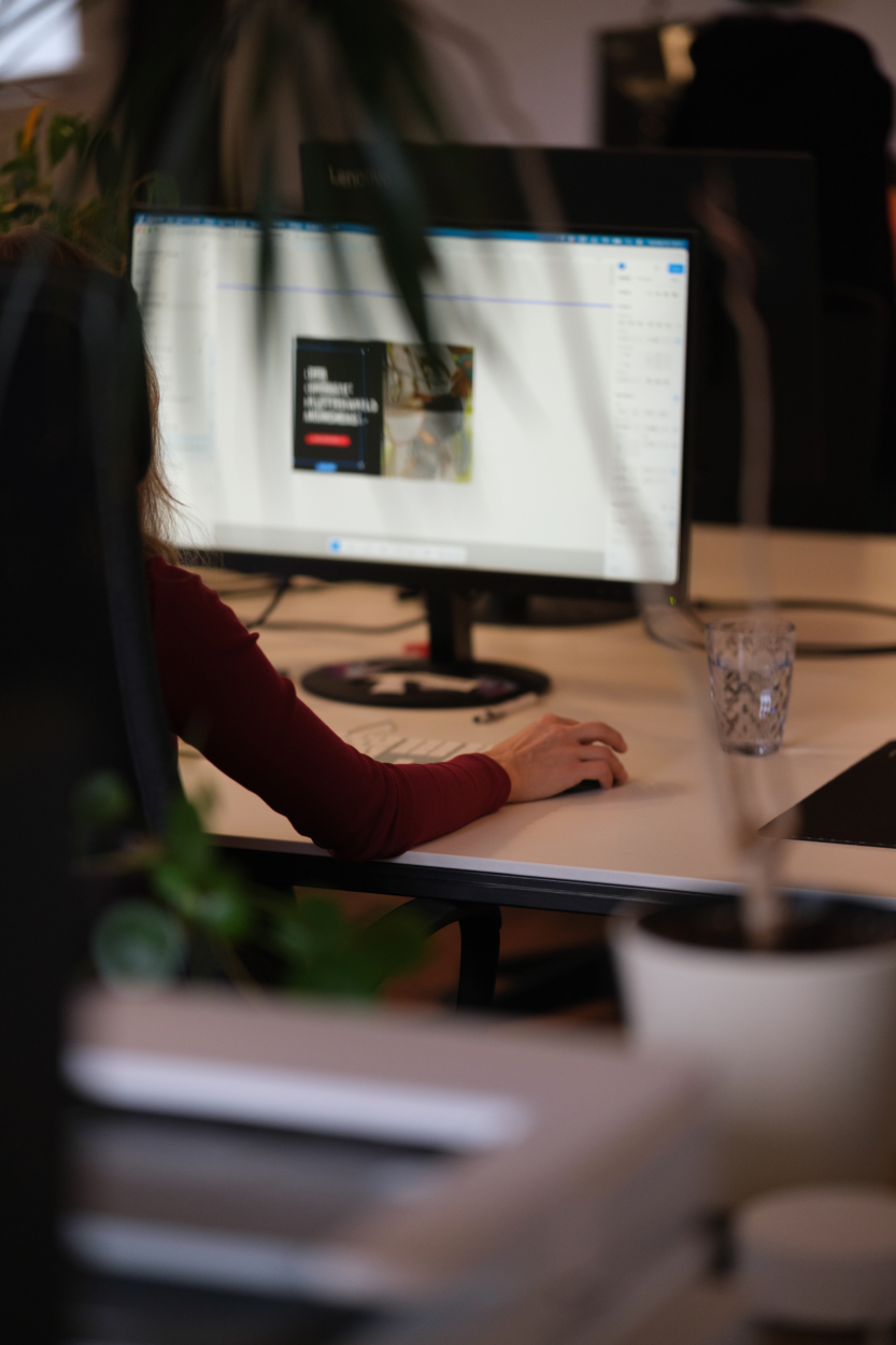 Eine Mitarbeiterin vor einem Laptop.