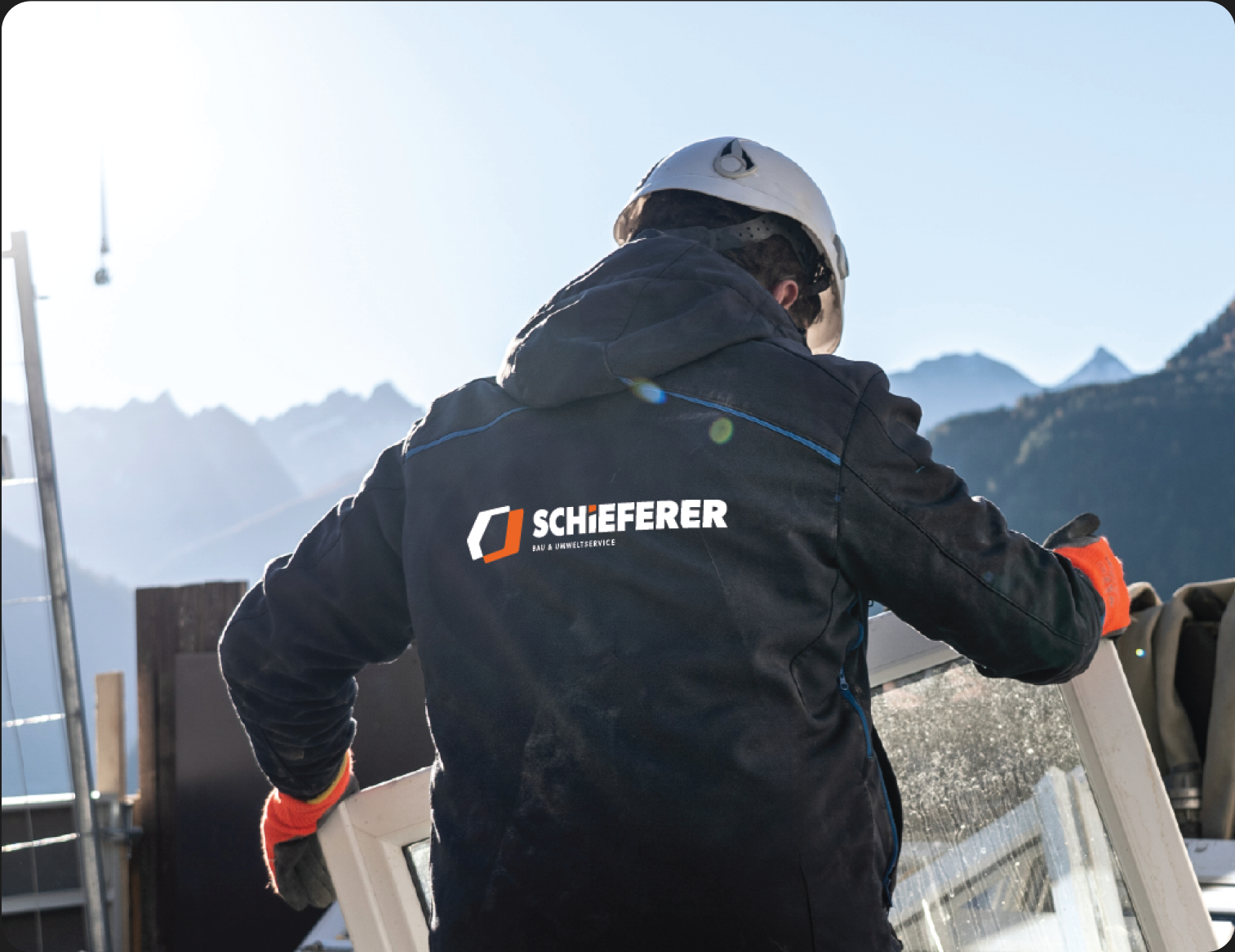 Ein Mitarbeiter trägt eine Jacke mit dem Schieferer Logo darauf